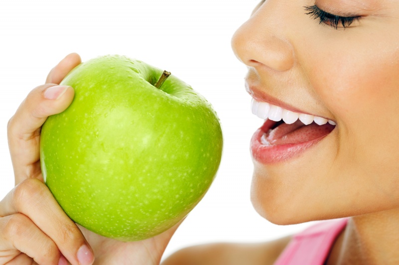 vrouw met witte tanden eet appel