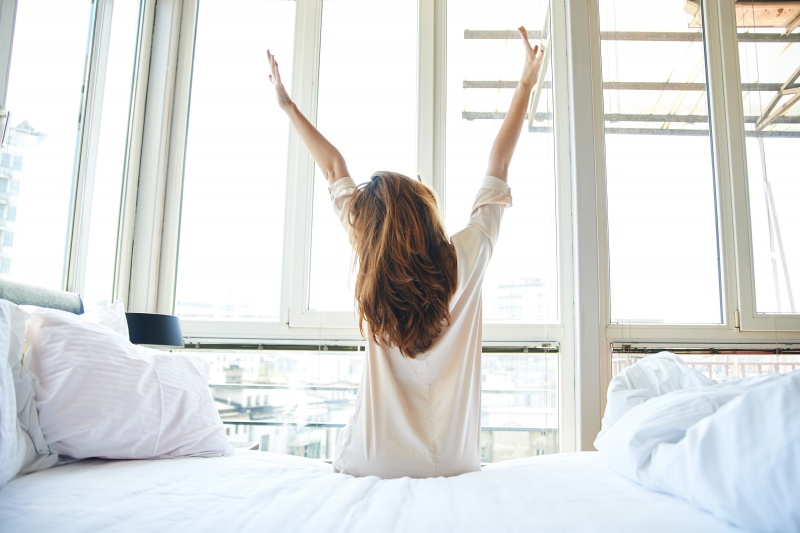 vrouw word wakker en rekt zich uit