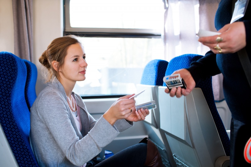 dame laat treinkaartje aan de conducteur zien